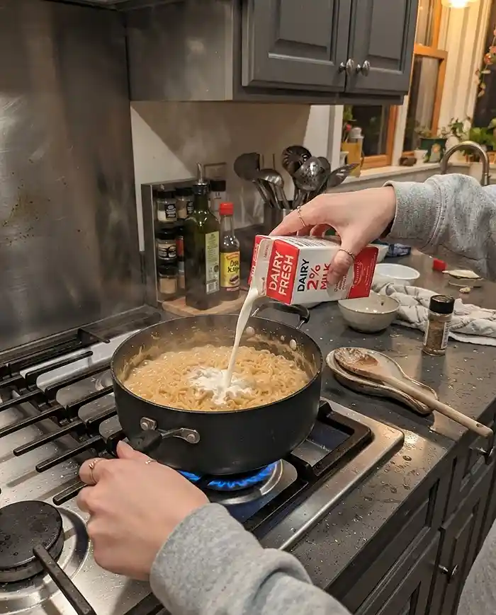 Buldak Carbonara Recipes 2 milk into a pot of buldak carbonara noodles on a stovetop to make the sauce extra creamy